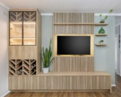 A modern living room setup featuring a wooden media unit with a mounted TV and a glass display cabinet
